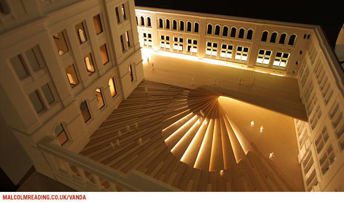 Sn&oslash;hetta & Hoskins concept model: night view of a physical study model showing the fanned canopy roof illuminated within the courtyard